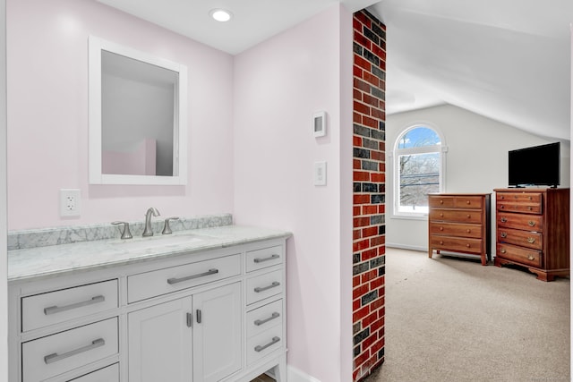 bathroom featuring lofted ceiling and vanity