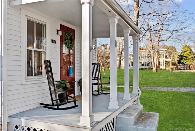 property entrance featuring a yard and covered porch