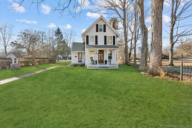 view of front facade featuring a porch, a front lawn, and a chimney