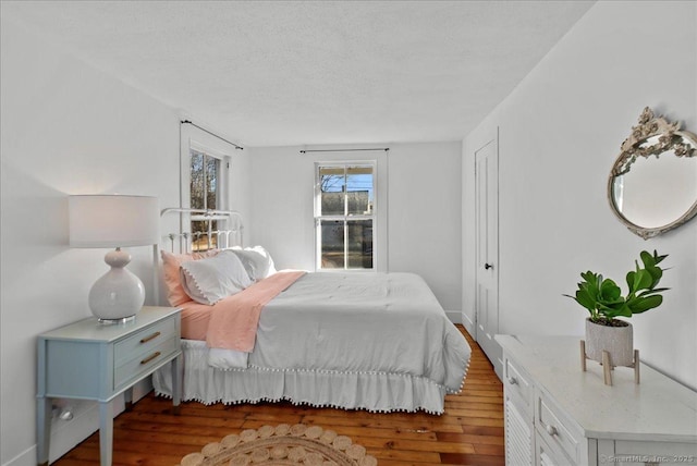 bedroom with wood finished floors and a textured ceiling