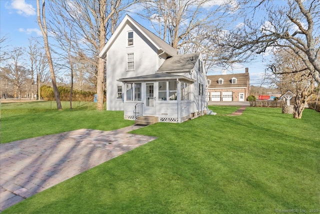 view of front facade featuring a front lawn, a garage, and a sunroom