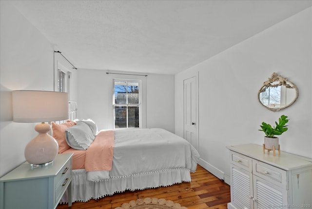 bedroom with wood finished floors and baseboards