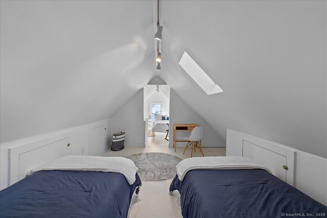 bedroom with vaulted ceiling with skylight and rail lighting