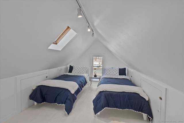 bedroom featuring lofted ceiling with skylight, track lighting, and a baseboard radiator