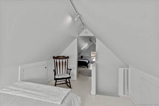 bedroom with vaulted ceiling and track lighting