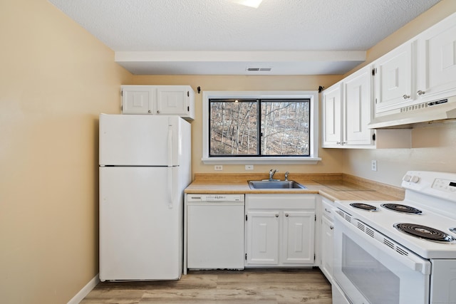 kitchen featuring light wood-type flooring, white appliances, sink, and white cabinets