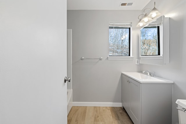 bathroom featuring vanity, hardwood / wood-style flooring, and toilet