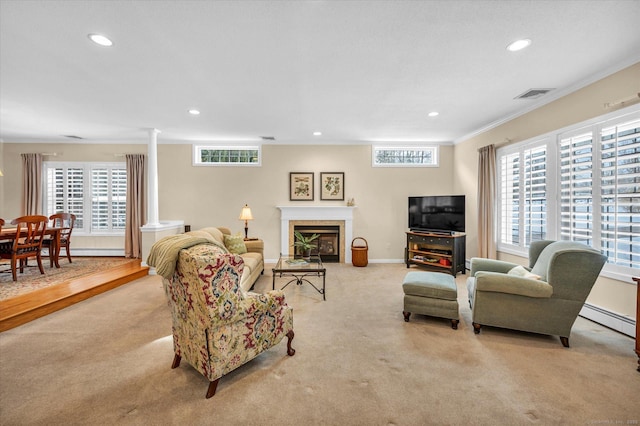 carpeted living room featuring crown molding and ornate columns