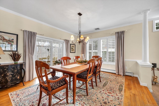 dining space featuring plenty of natural light, light hardwood / wood-style floors, and ornate columns