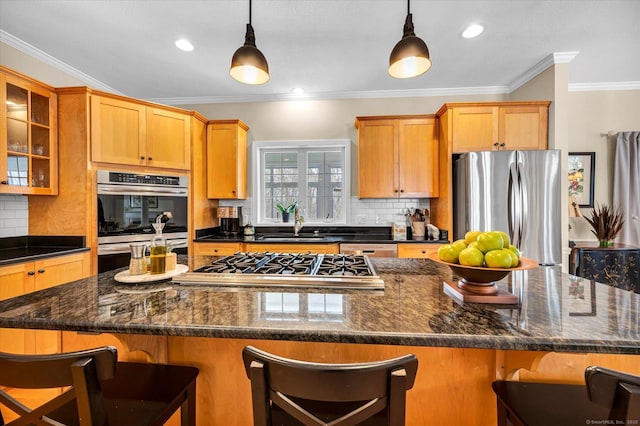 kitchen with appliances with stainless steel finishes, a kitchen bar, and decorative light fixtures