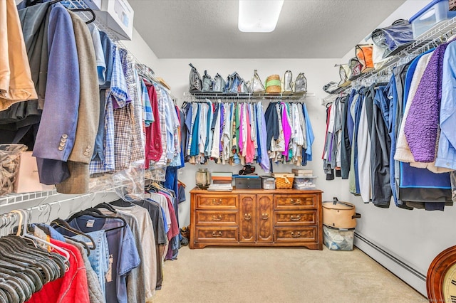 walk in closet with light carpet and a baseboard heating unit