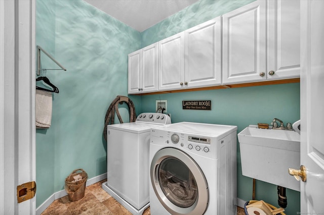 laundry area with cabinets, washer and dryer, and sink