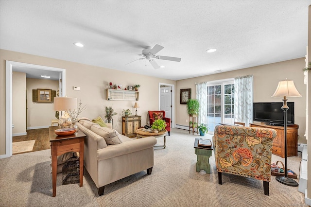 living room with baseboard heating, light carpet, and a textured ceiling