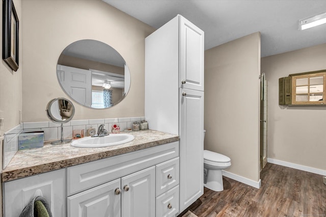 bathroom featuring vanity, wood-type flooring, and toilet