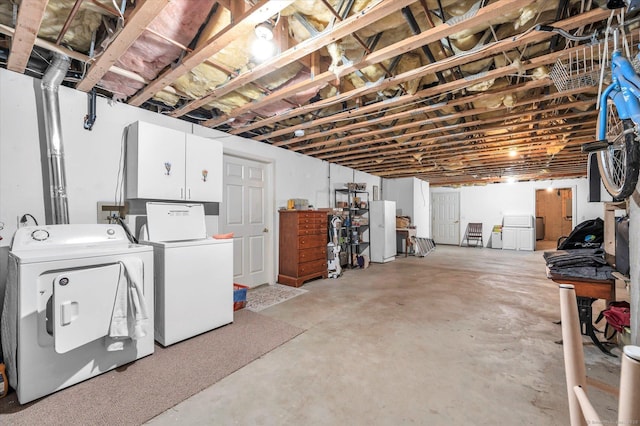 basement with washing machine and dryer and white refrigerator