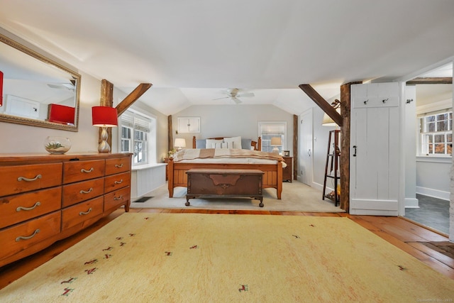 bedroom featuring ceiling fan, light hardwood / wood-style floors, multiple windows, and lofted ceiling