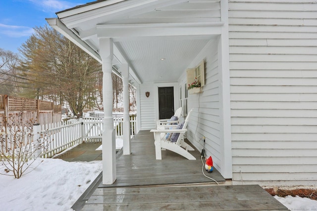 snow covered deck with a porch