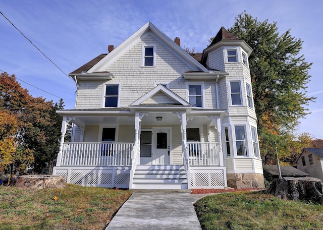 victorian house with a porch and a front yard