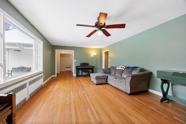 living room with ceiling fan, radiator heating unit, and light hardwood / wood-style flooring