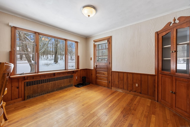 spare room with ornamental molding, radiator, and light hardwood / wood-style flooring