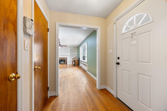 entrance foyer featuring radiator, ceiling fan, and light wood-type flooring