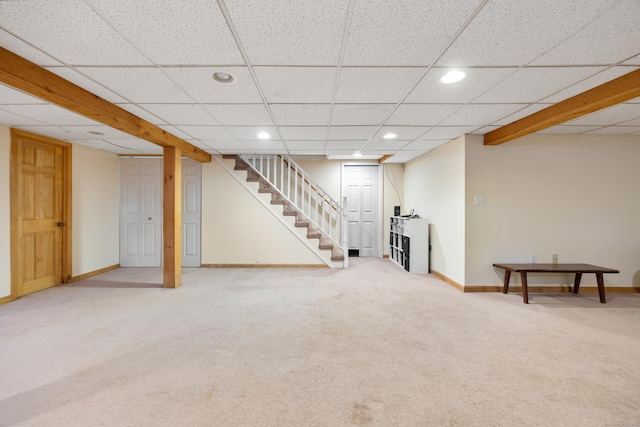 basement with a paneled ceiling and carpet