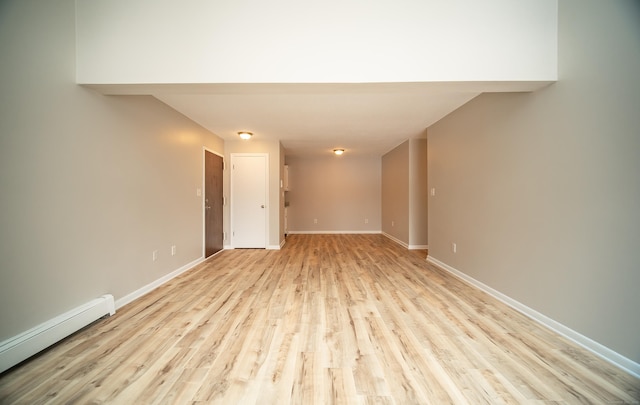 spare room featuring a baseboard radiator and light hardwood / wood-style flooring