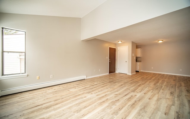 unfurnished living room with baseboard heating, a healthy amount of sunlight, and light hardwood / wood-style floors