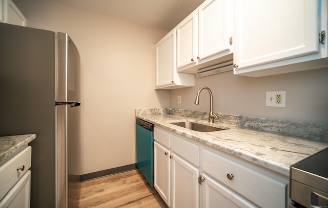 kitchen featuring white cabinetry, sink, light stone counters, stainless steel appliances, and light wood-type flooring