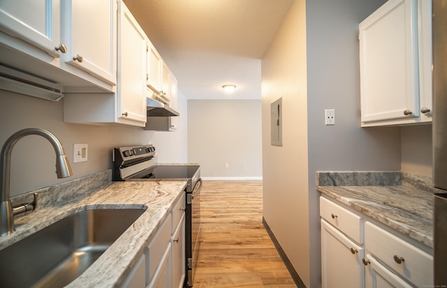 kitchen featuring light stone counters, stainless steel range with electric stovetop, sink, and white cabinets