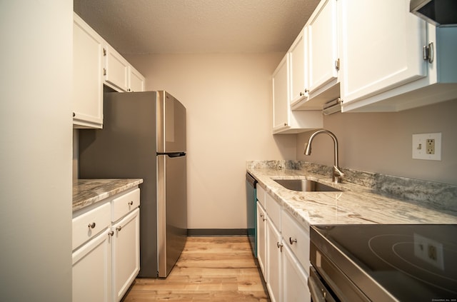 kitchen with white cabinetry, sink, stainless steel fridge, electric range, and light stone counters