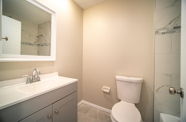 bathroom with vanity, a tile shower, and toilet