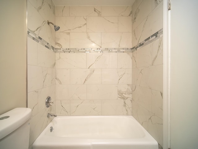 bathroom featuring tiled shower / bath combo and toilet