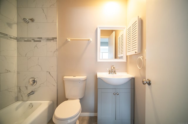 full bathroom featuring vanity, tiled shower / bath, and toilet