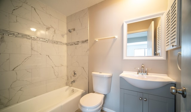 full bathroom featuring tiled shower / bath, vanity, and toilet