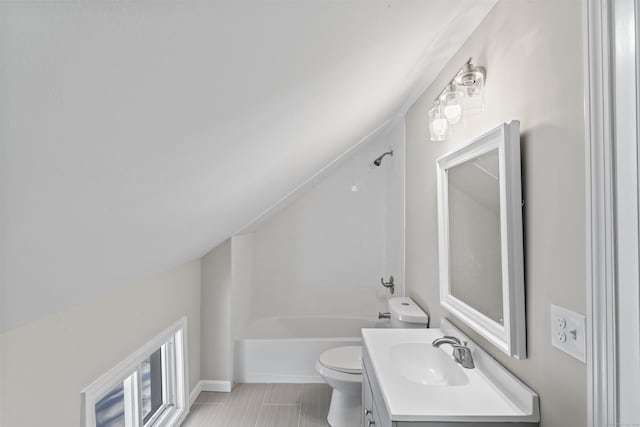 full bathroom with vanity, tiled shower / bath combo, vaulted ceiling, and toilet