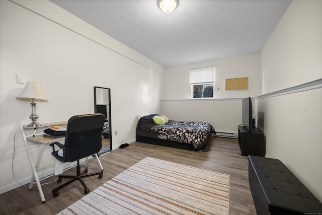 bedroom featuring baseboard heating and wood-type flooring