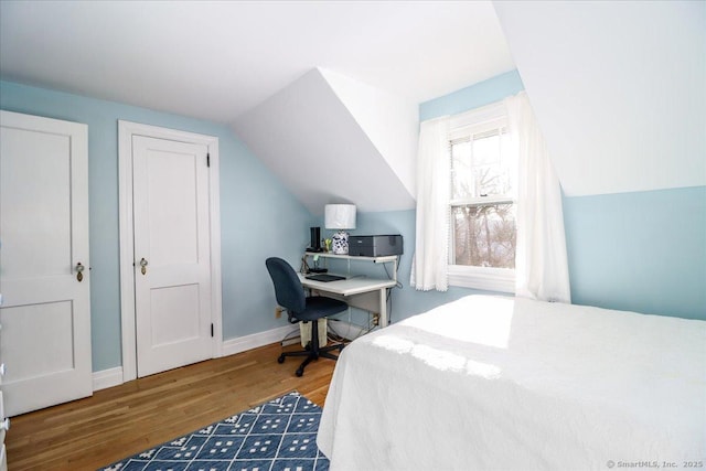 bedroom with vaulted ceiling and dark wood-type flooring