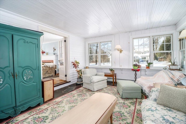 sunroom with wood ceiling, a baseboard radiator, and plenty of natural light