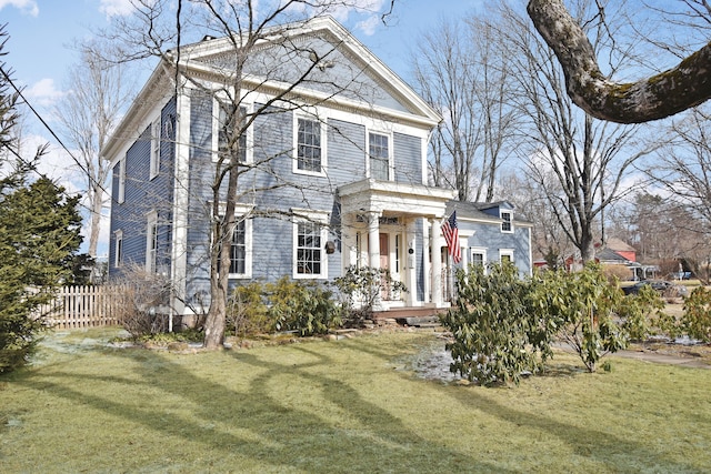 neoclassical home featuring a front lawn