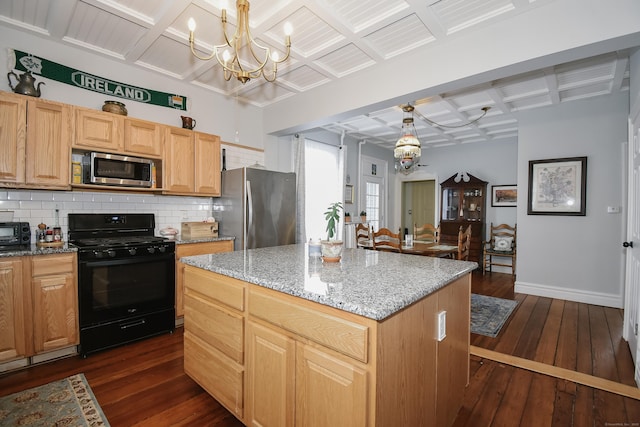 kitchen with coffered ceiling, a center island, hanging light fixtures, a notable chandelier, and stainless steel appliances