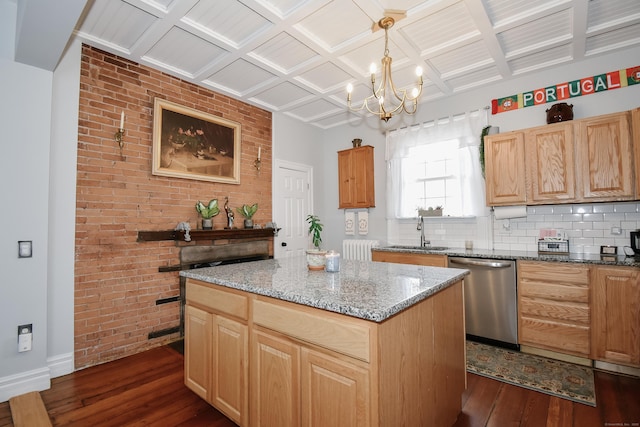 kitchen with coffered ceiling, sink, hanging light fixtures, dishwasher, and a kitchen island