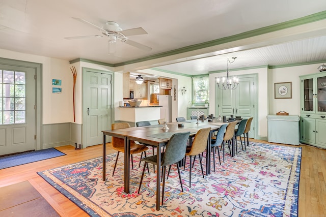 dining space featuring ceiling fan with notable chandelier, light hardwood / wood-style flooring, and ornamental molding