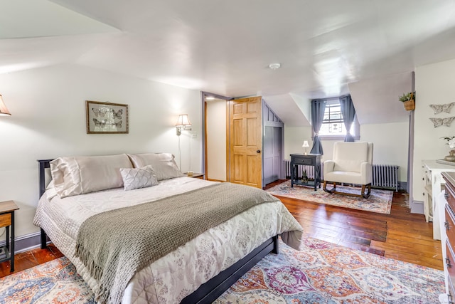 bedroom featuring dark hardwood / wood-style floors, radiator, and vaulted ceiling