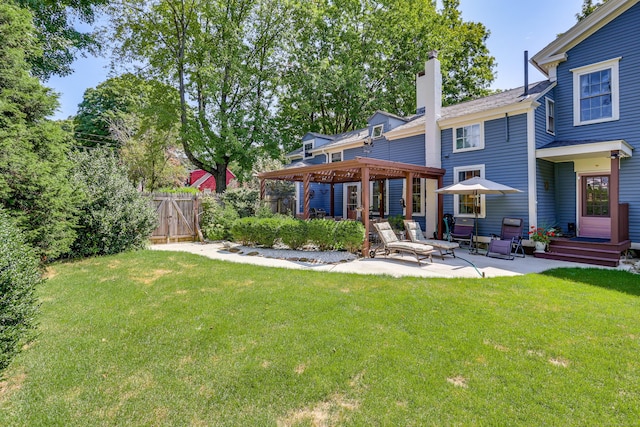 rear view of house featuring a yard and a patio area