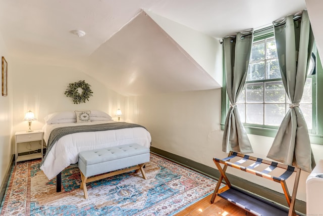 bedroom with hardwood / wood-style floors and vaulted ceiling