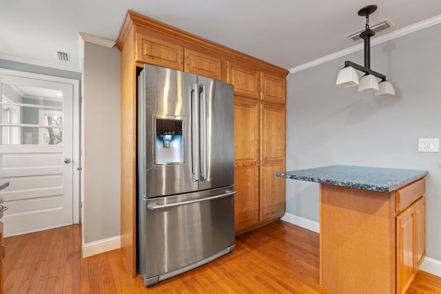 kitchen with stone counters, crown molding, light wood-type flooring, and stainless steel fridge with ice dispenser