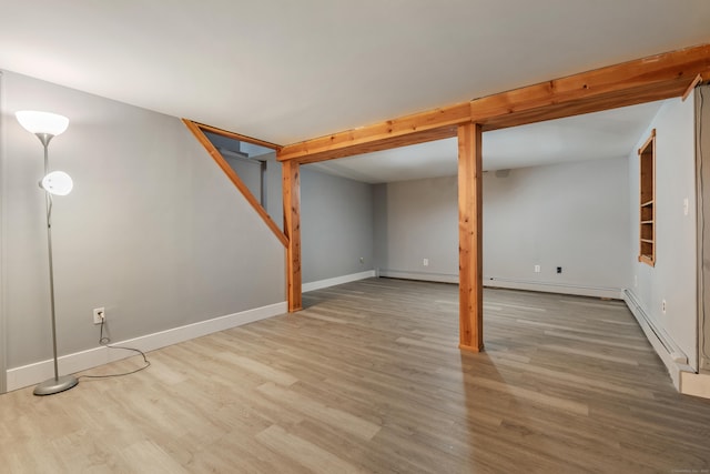 basement featuring hardwood / wood-style flooring and baseboard heating