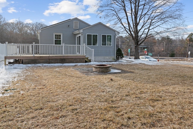 view of front of property with a wooden deck, an outdoor fire pit, and a front yard