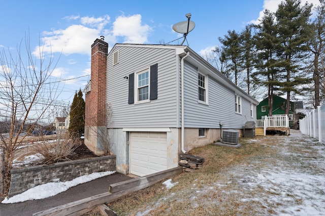 view of side of property with a garage and central air condition unit